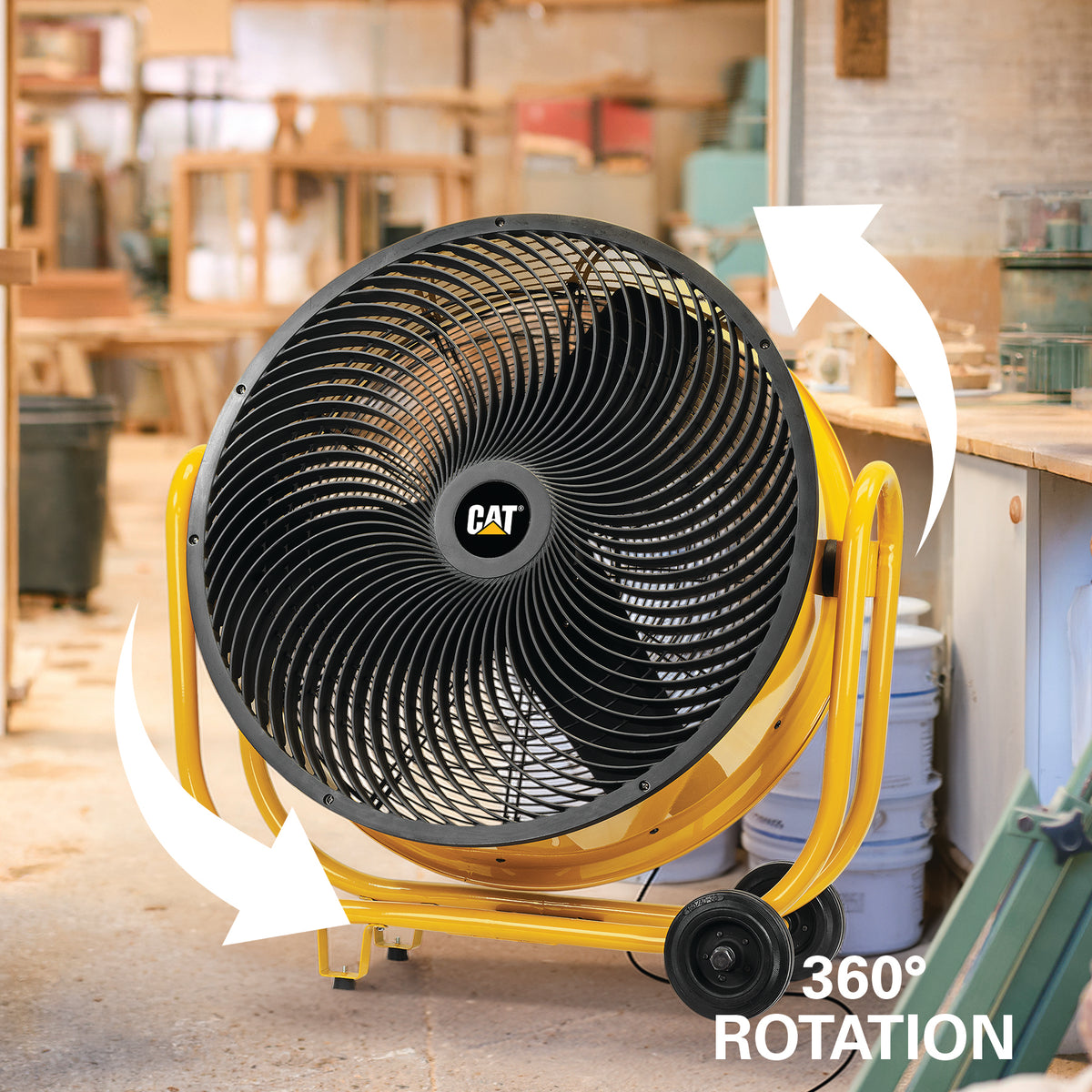 A large CAT industrial fan with a yellow frame and black grille, shown in a workshop setting with white arrows indicating 360° rotation.