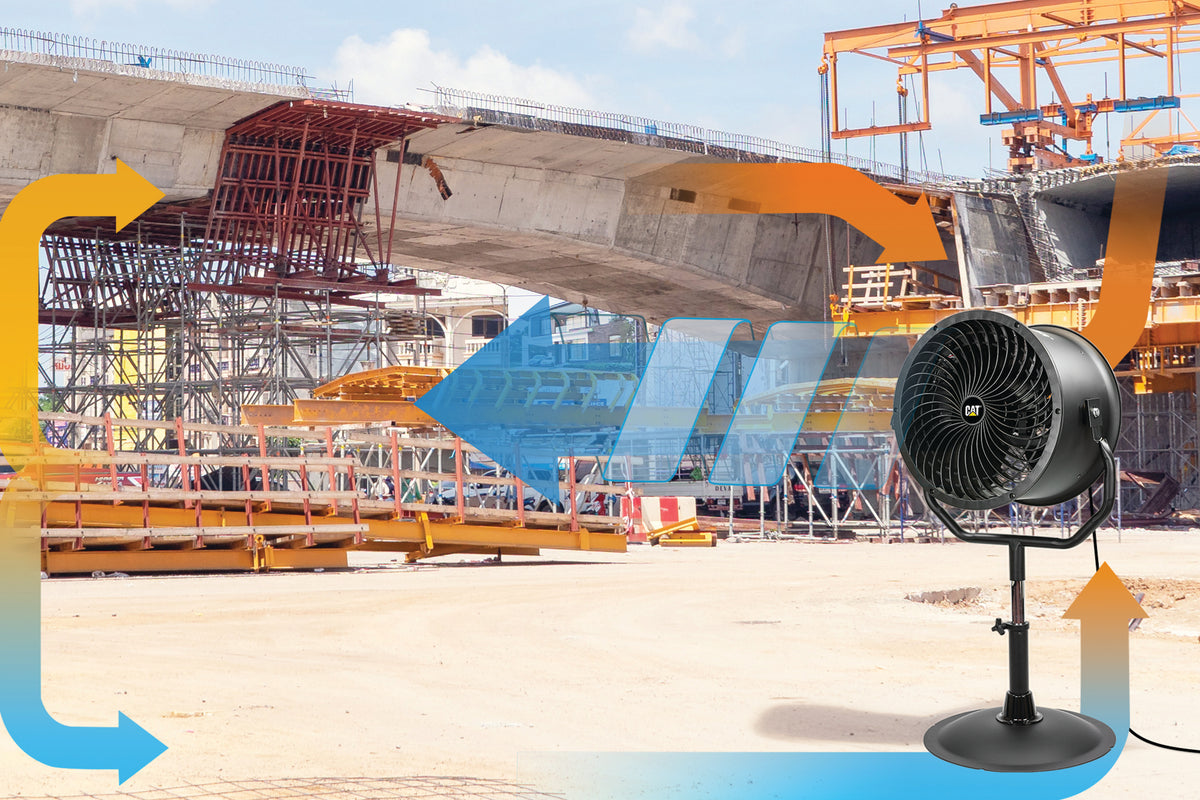 A black industrial fan on a stand in the foreground, with blue and orange airflow graphics overlaid over a construction site background featuring a large concrete bridge structure.