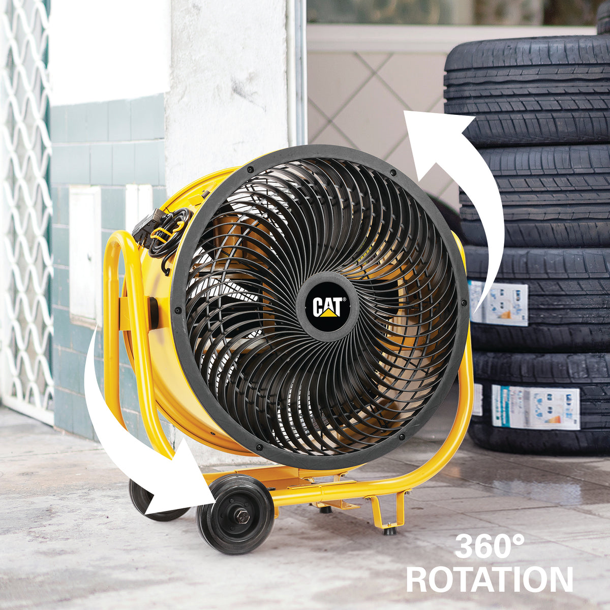 A yellow and black CAT industrial floor fan with dual wheels, shown in a garage-like setting with white arrows indicating 360° rotation and text reading '360° ROTATION'.