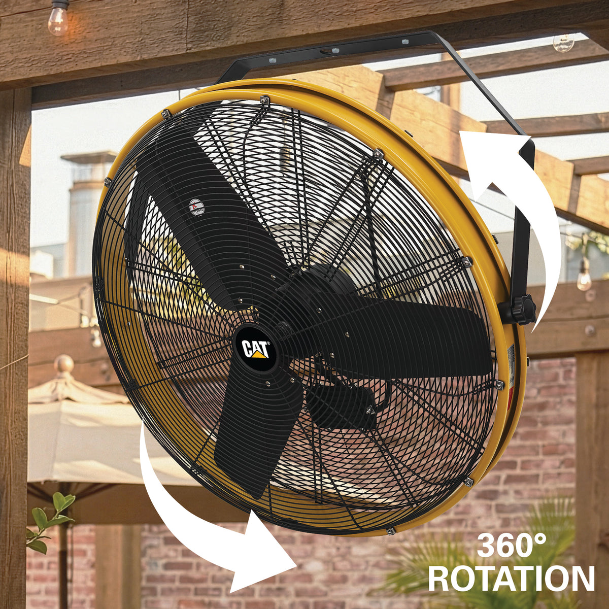 A large yellow CAT industrial ceiling fan shown hanging in a wooden pergola outdoors, with white arrows indicating 360° rotation and the text '360° ROTATION' in the lower right.