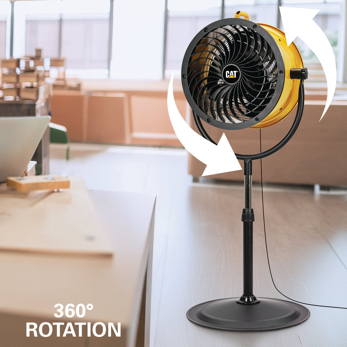 A yellow CAT pedestal fan on a stand in a modern indoor room, with white arrows and text reading '360° ROTATION' to show the airflow feature.